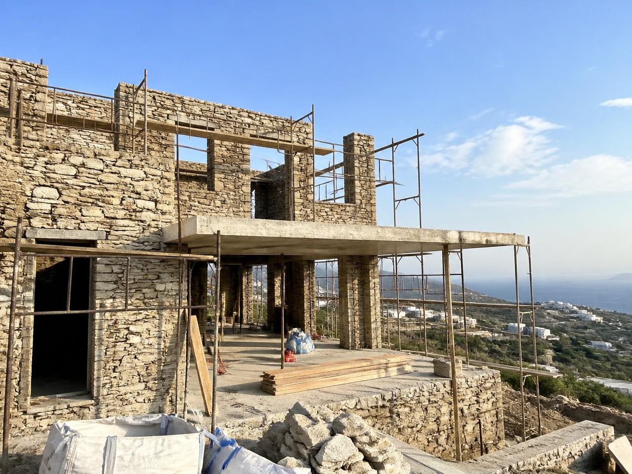 Villa B in Naxos under construction, stone walls and scaffolding on the Kastraki hillside