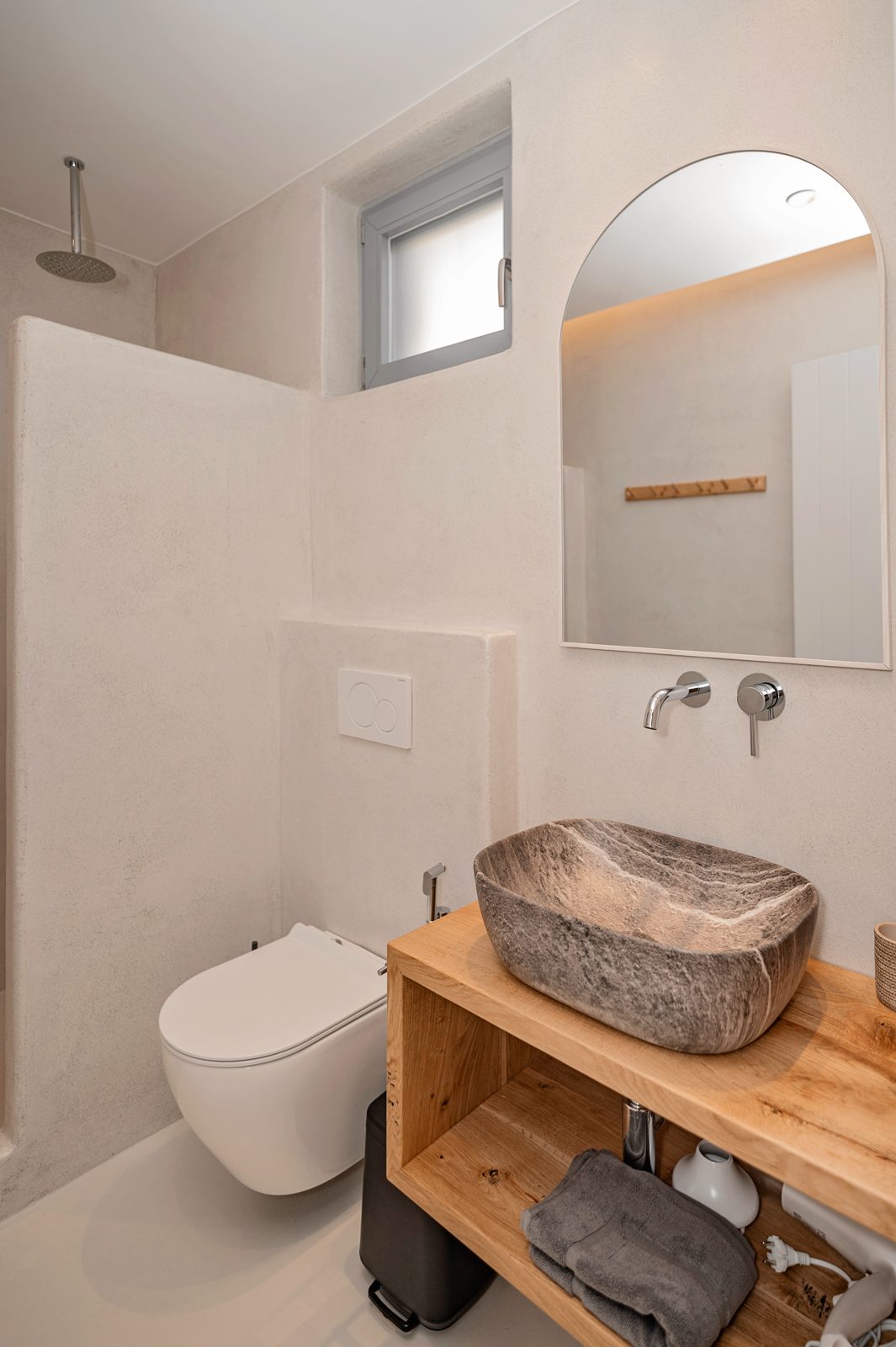 Bathroom of Villa A in Naxos with a carved stone basin, oak vanity and walk-in shower