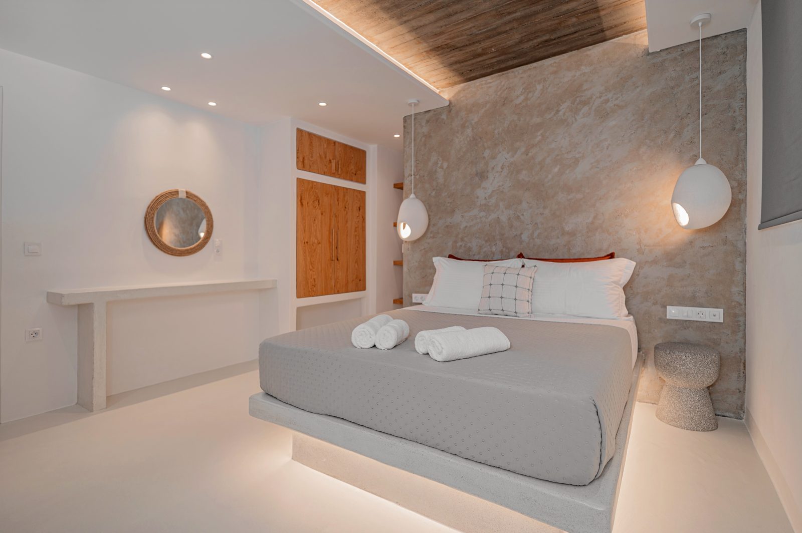 Second bedroom of Villa A in Naxos with a textured plaster wall and pendant bedside lights