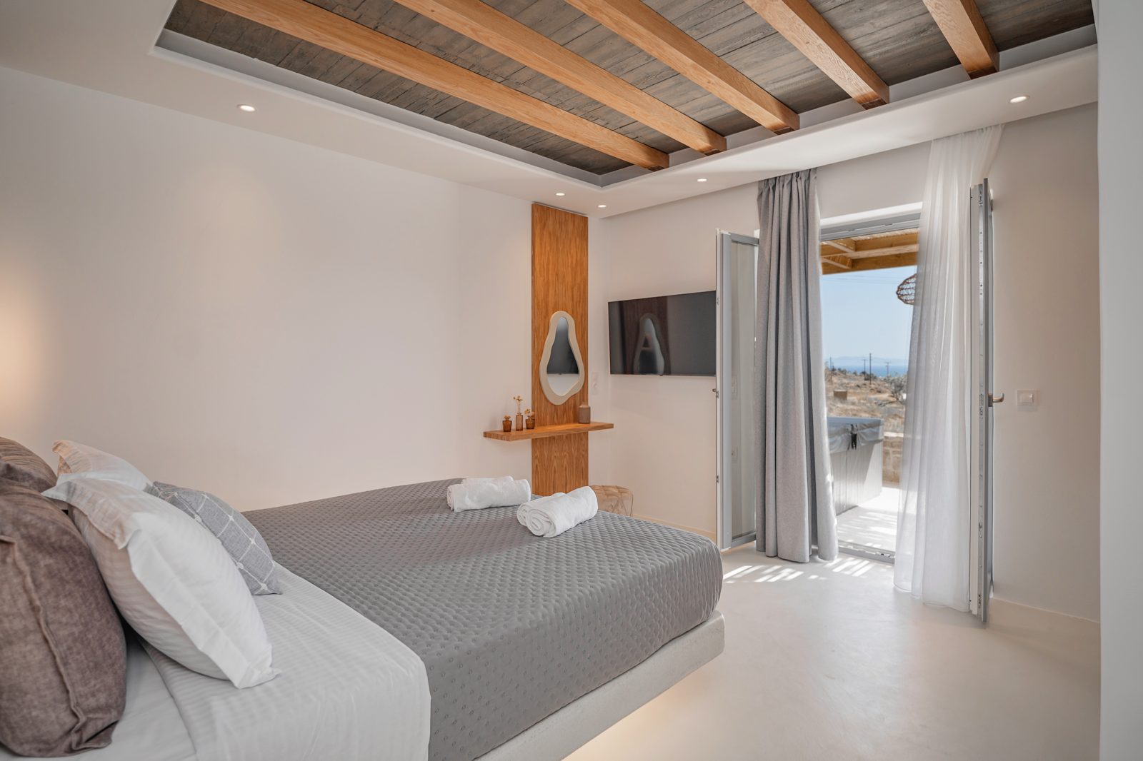 Master bedroom of Villa A in Naxos with double doors opening to the terrace and sea view