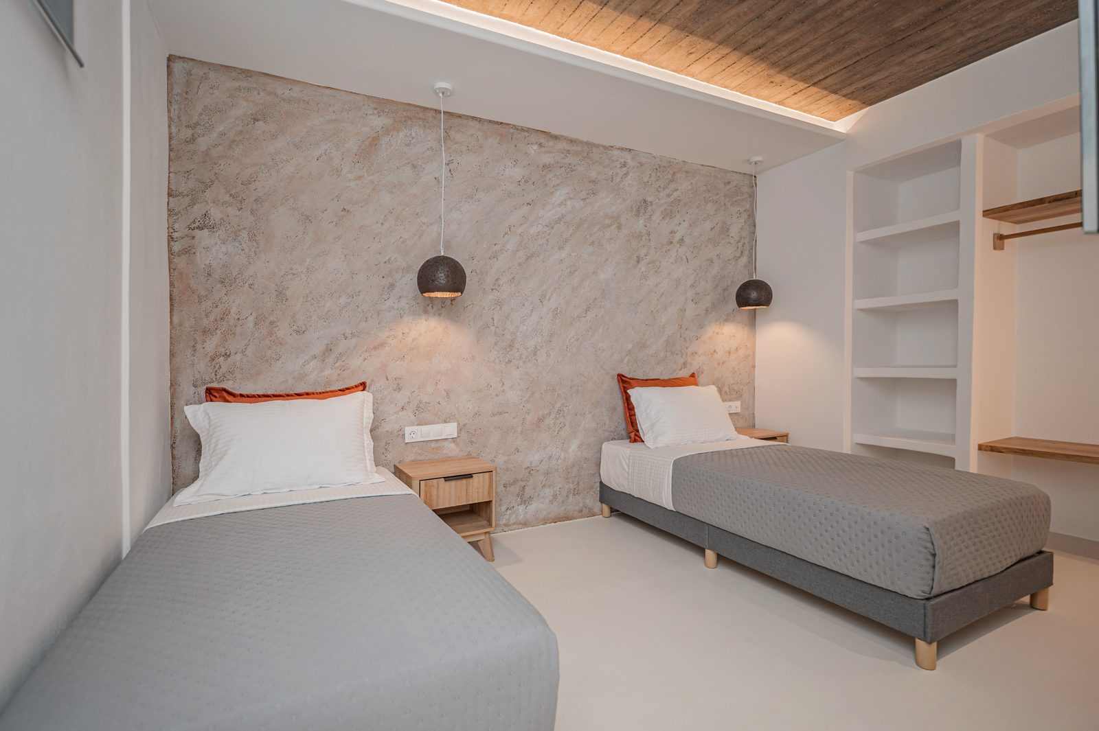 Twin bedroom of Villa A in Naxos with two single beds and open shelving